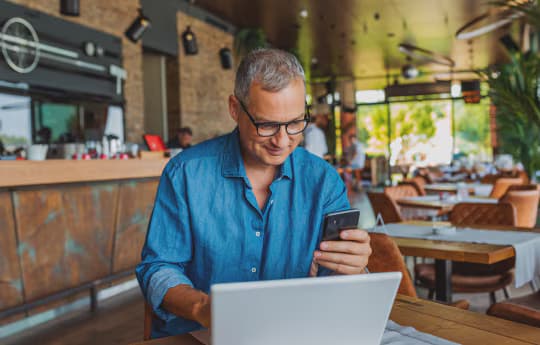 pessoa usando notebook e celular